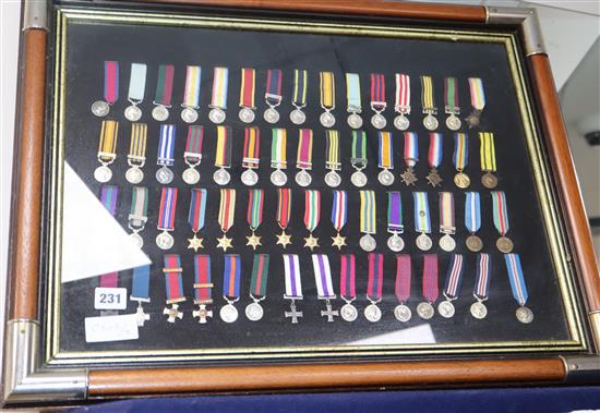 A framed collection of WWI and WWII miniature medals